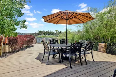 a table and chairs with an umbrella on a deck at Lakefront village castle #2312 in Big Bear Lake