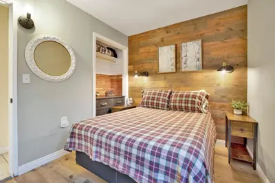 a bedroom with a bed with a plaid blanket and a mirror at Beary cozy cabin #2315 in Big Bear Lake