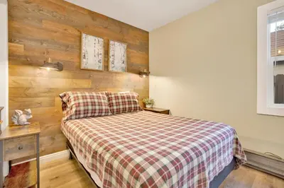 a bedroom with a bed and a wooden wall at Beary cozy cabin #2315 in Big Bear Lake