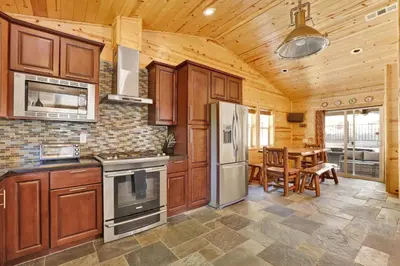 a kitchen with wooden cabinets and a dining room with a table at Circle views #1602 in Big Bear Lake