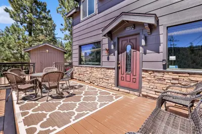 a home with a wooden deck with a red door at Circle views #1602 in Big Bear Lake
