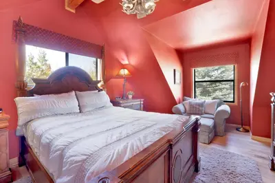 a bedroom with a large bed with red walls at Knotty and nice #177 in Big Bear Lake