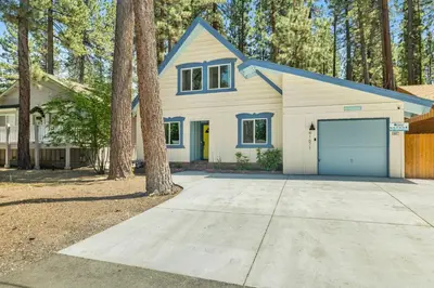 a white house with a blue garage at Blue bear chalet #2045 in Big Bear Lake