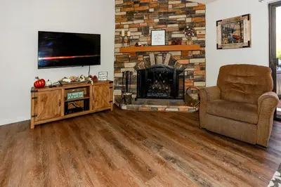 a living room with a fireplace and a chair and a television at Cienega getaway #1952 in Big Bear Lake