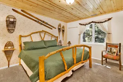 a bedroom with a bed and a wooden ceiling at Cove lakefront chalet #2098 in Big Bear Lake