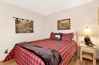 a bedroom with a bed and a table with a lamp at Mockingbird mountain getaway #2380 in Big Bear Lake