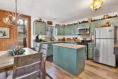 a kitchen with green cabinets and a white refrigerator at Mockingbird mountain getaway #2380 in Big Bear Lake