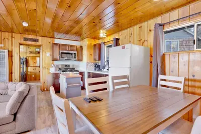 a kitchen and dining room with a wooden table in a tiny house at Sunrise #108 in Big Bear Lake