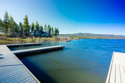 a view of a lake with a house and a dock at Juniper #105 in Big Bear Lake