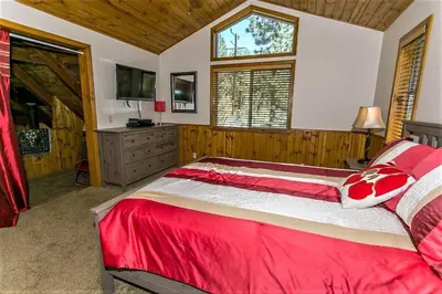 a bedroom with a bed with red and white pillows at Grandpas axe # 1775 in Big Bear Lake