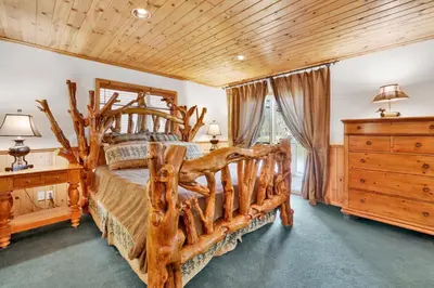 a bedroom with a large bed made out of logs at Fishermans paradise #1792 in Big Bear Lake