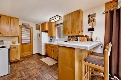a kitchen with wooden cabinets and a white refrigerator at POPKO'S PLACE #1426 in Big Bear Lake