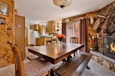 a dining room with a wooden table and a fireplace at POPKO'S PLACE #1426 in Big Bear Lake