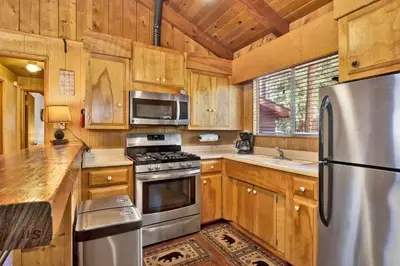 a kitchen with wooden cabinets and a stainless steel refrigerator at Pine cone cottage #2191 in Big Bear Lake