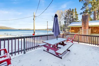 a picnic table with an umbrella and chairs on a deck at Lakeside #109 in Big Bear Lake