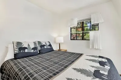 a bedroom with a bed and a window at Breezy two #113 in Big Bear Lake