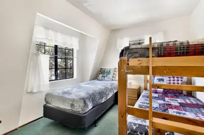 a bedroom with two bunk beds and a window at Breezy two #113 in Big Bear Lake