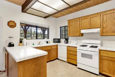 a kitchen with white appliances and wooden cabinets at Breezy two #113 in Big Bear Lake
