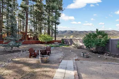 a backyard with chairs and tables and trees at The alps lodge #2142 in Big Bear Lake