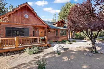 a log cabin with a porch and a tree at The alps lodge #2142 in Big Bear Lake
