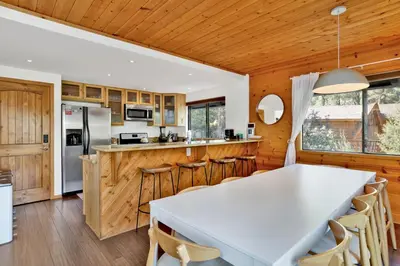 a kitchen with a white table and wooden walls at Chimney Peak Chalet#2048 in Big Bear City