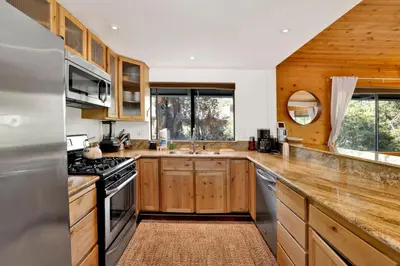 a kitchen with wooden cabinets and a stove top oven at Chimney Peak Chalet#2048 in Big Bear City