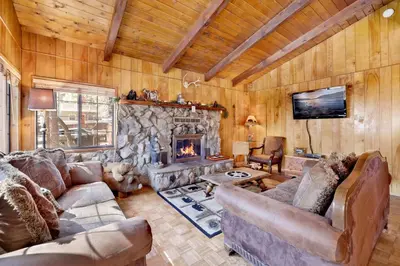 a living room with couches and a stone fireplace at Casa catalina #667 in Big Bear Lake
