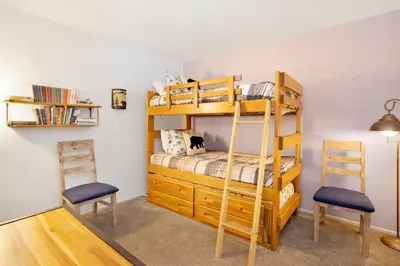 a bedroom with a bunk bed and two chairs at BROWNIE'S DEN #2205 in Big Bear Lake