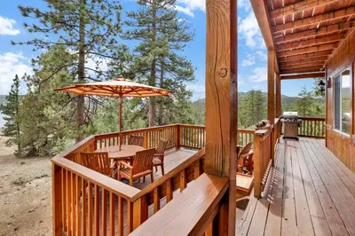 a wooden deck with a table and an umbrella at Cozy lakeview hideaway #2261 in Fawnskin