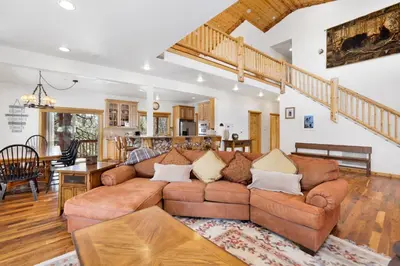 a living room with a brown couch and a table at Cozy lakeview hideaway #2261 in Fawnskin