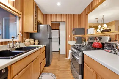 a kitchen with wooden cabinets and a black refrigerator at Big bear happy place #2421 in Big Bear Lake