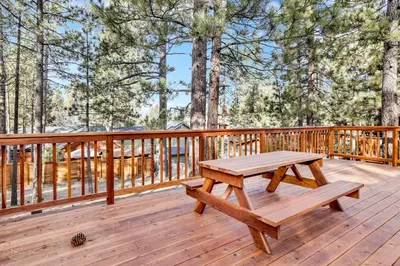 a wooden deck with a picnic table on it at Kozy cabin #2386 in Big Bear Lake