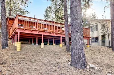 a house with a deck in the woods at Kozy cabin #2386 in Big Bear Lake