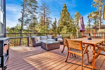 a deck with a couch and a table and chairs at Pine meadow village castle #2301 in Big Bear Lake