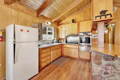a kitchen with a white refrigerator and wooden cabinets at Marin getaway #2013 in Big Bear Lake
