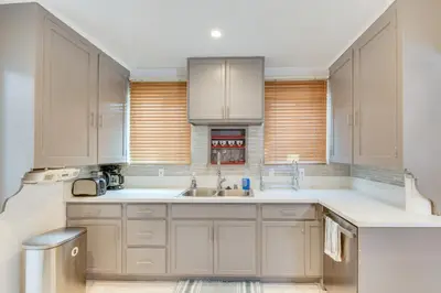 a kitchen with white cabinets and a sink at 1 Mi to Melrose Ave and Grove! Upscale LA Retreat in Los Angeles