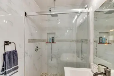 a white bathroom with a shower and a sink at 1 Mi to Melrose Ave and Grove! Upscale LA Retreat in Los Angeles