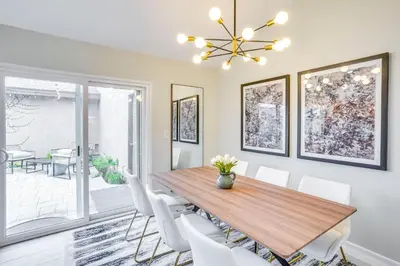 a dining room with a wooden table and white chairs at Idyllic Tustin Home with Private Patio and Grill in Tustin