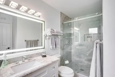 a white bathroom with a sink and a shower at Idyllic Tustin Home with Private Patio and Grill in Tustin