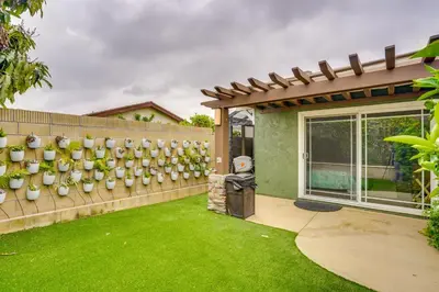 a backyard with a fence with plants on it at Lovely Tustin Home with Outdoor Kitchen 3 Mi to Zoo in Tustin