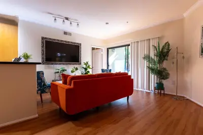 a living room with a red couch and a flat screen tv at Urban Haven at Orsini in Los Angeles