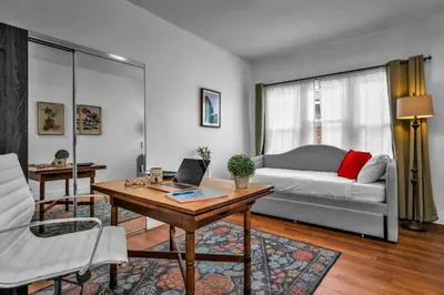 a living room with a couch and a table with a laptop at Gramercy Getaway in Los Angeles