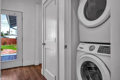 a laundry room with a washing machine and a door at Gramercy Getaway in Los Angeles