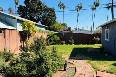 a backyard with a fence and a yard with a house at Gramercy Getaway in Los Angeles