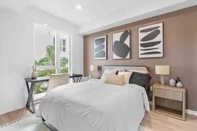 a bedroom with a white bed and a desk at Luxury & Modern Apt by the Grove in Los Angeles