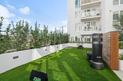 a garden with artificial grass and a fence at Luxury & Modern Apt by the Grove in Los Angeles