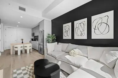 a living room with a white couch and a kitchen at Epitome of Luxury Condo in DTLA in Los Angeles