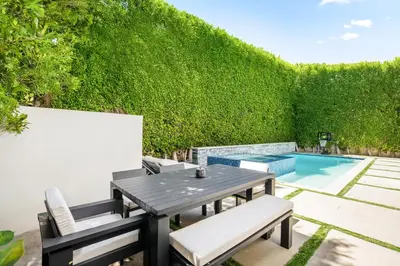 a patio with a table and chairs and a swimming pool at Luxurious Retreat - Modern House with Pool in Los Angeles