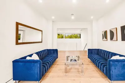 a living room with blue couches and a table at Luxurious Retreat - Modern House with Pool in Los Angeles