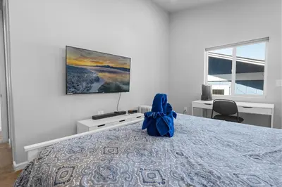 a person sitting on a bed in a bedroom at Modern Lakefront Dream Home Steps from Big Bear Village in Big Bear Lake